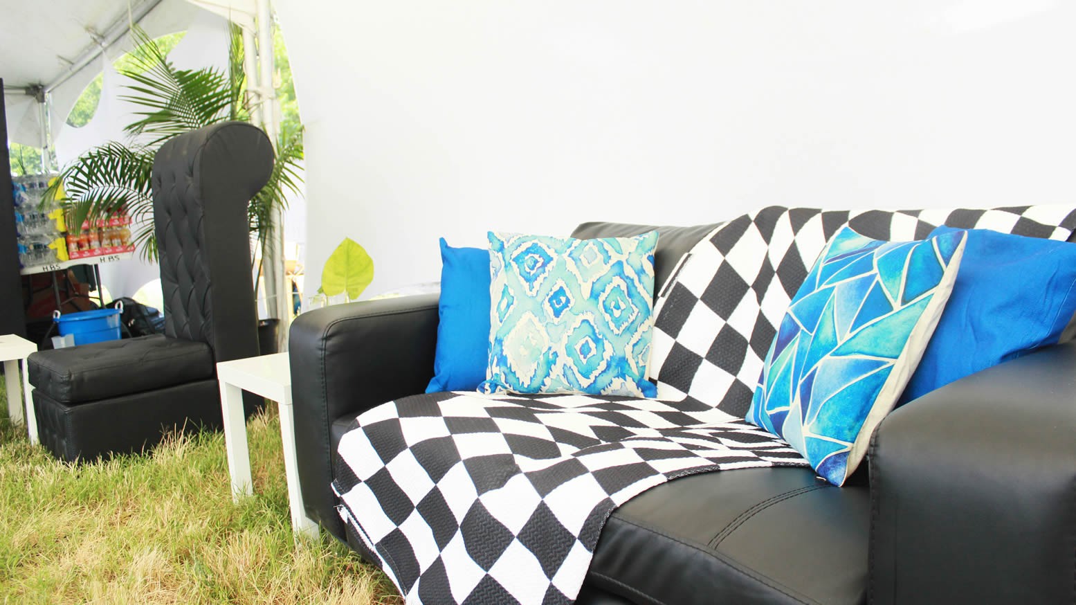 a black lounge chair with a checkerboard throw blanket and blue pillows eccessories by ellen www.eccessoriesbyellen.com