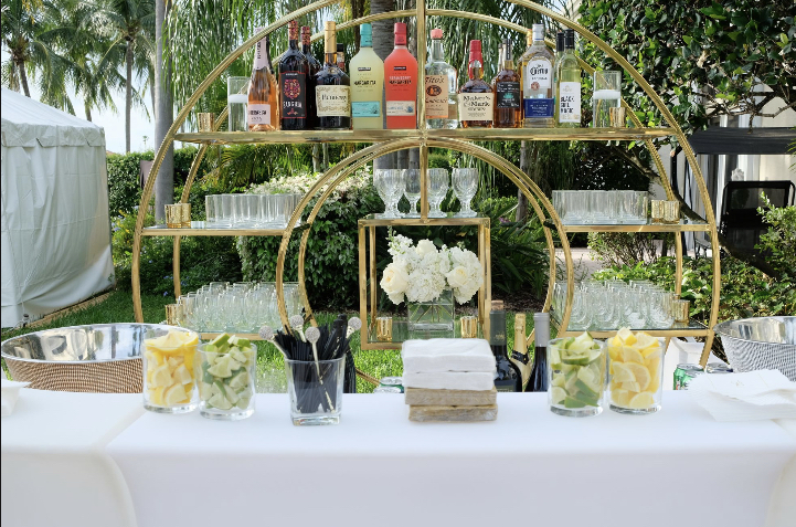 bar stand with wine and liquor bottles with serving glasses and lemon and lime garnish containers eccessories by ellen www.eccessoriesbyellen.com